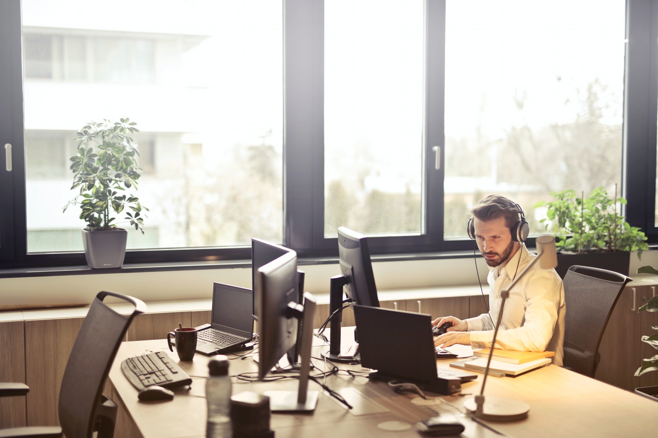 Homme sur un ordinateur avec un casque audio